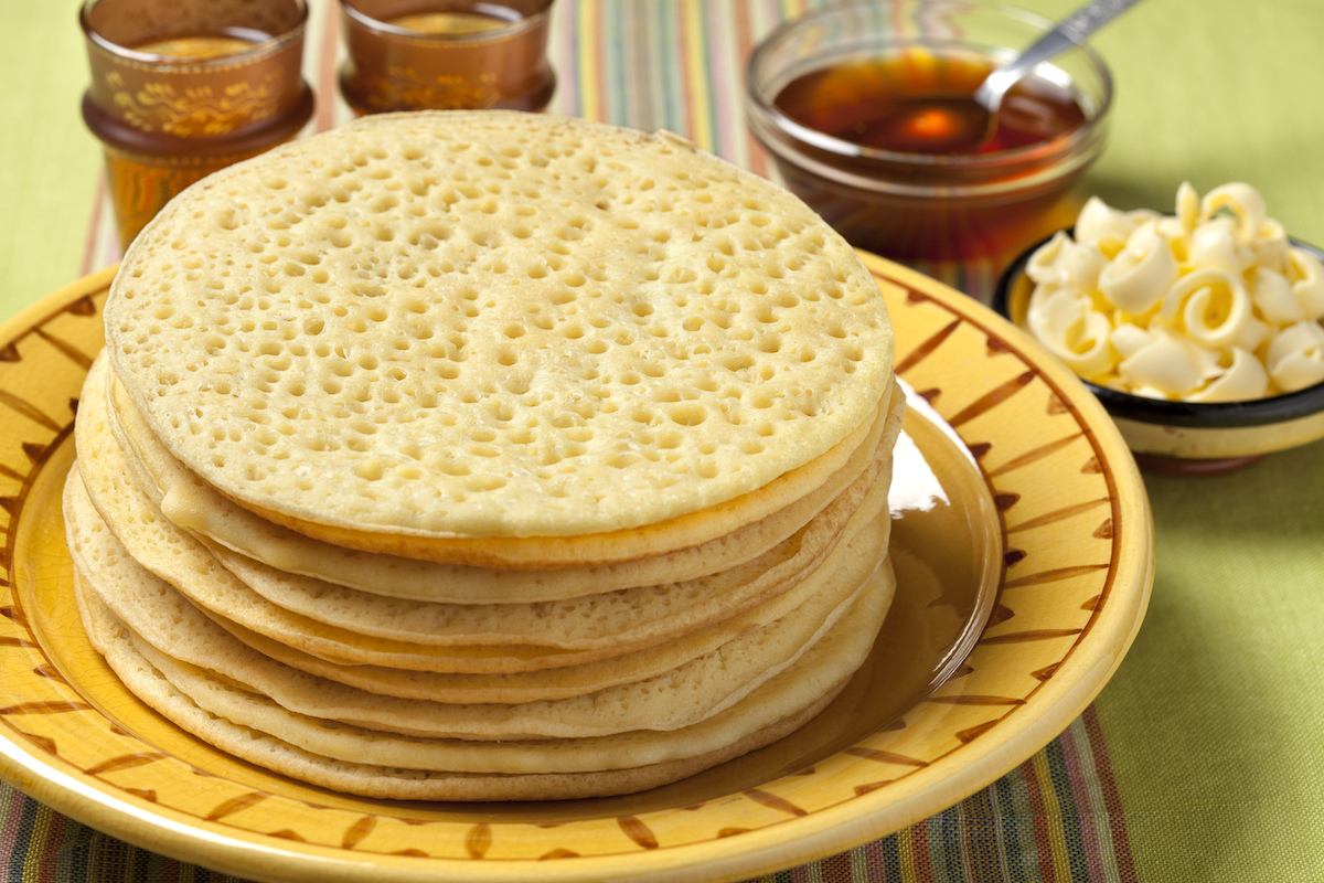 Heap of Moroccan beghrir pancakes served with honey and butter